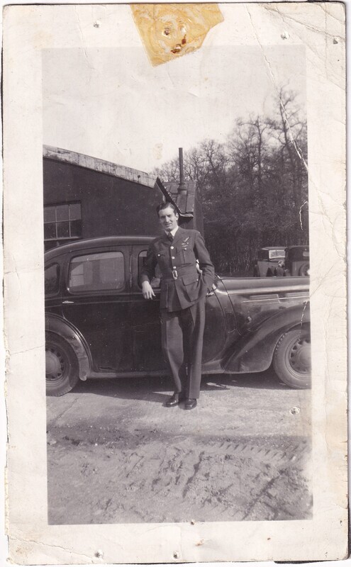 Unidentified man standing beside a car, front