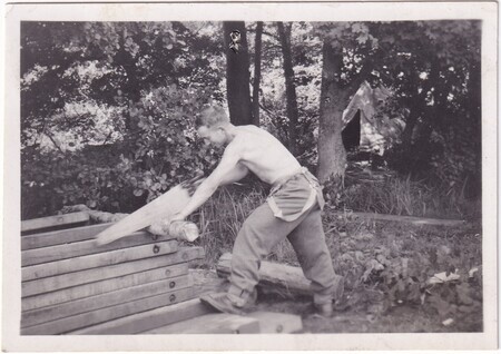 A photo of W.I. (Bill) Hann cutting wood with a hand saw taken in [East Anglia] England
