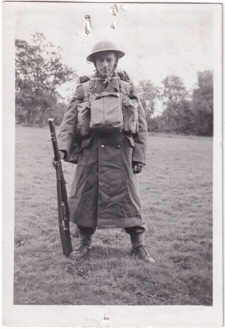 A photo of W.I. (Bill) Hann standing in a field wearing his army uniform in full kit taken in [East Anglia] England
