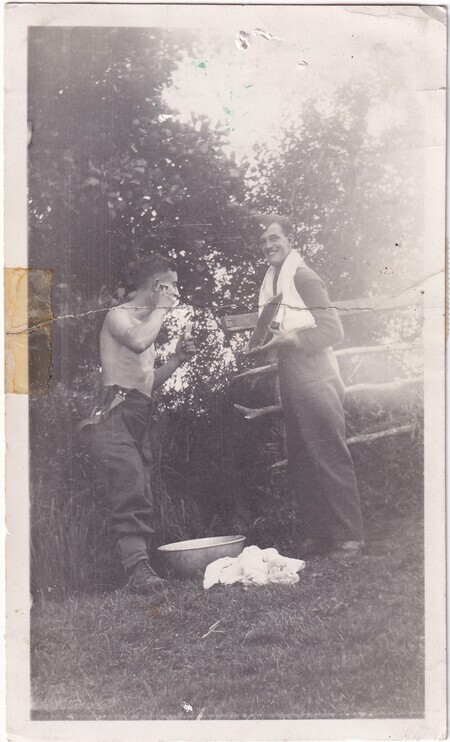 A photo of W.I. (Bill) Hann shaving using a mirror held by A.C. Baker taken somewhere in [East Anglia] England