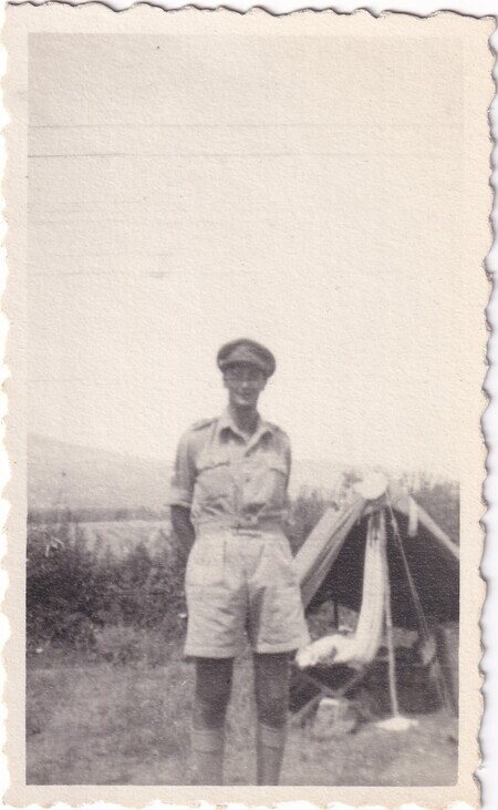 A photo of an unidentified man standing in front of his tent [taken in Italy]