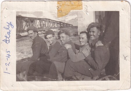 A photo of a group of soldiers taken in the Apennine mountains of Italy [seated on a sled/toboggan]